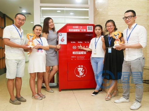 恒昌公司愛心員工在恒昌“溫暖家+”衣物捐獻箱前合影